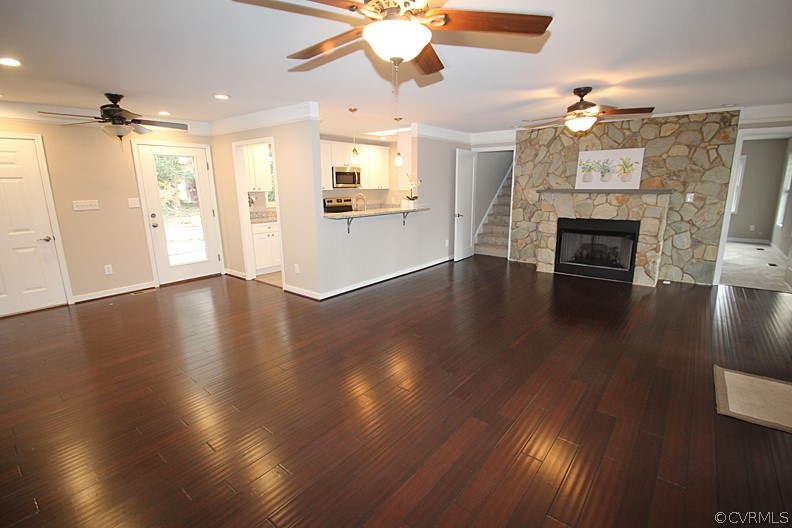 2809 Banbury Road Chester, VA 23831 - Photo 5 of 47 an empty room with wooden floor fireplace and kitchen view