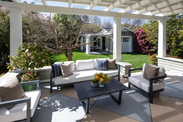 a view of a patio with couches table and chairs and garden