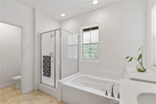 a bathroom with a tub double sink window and mirror