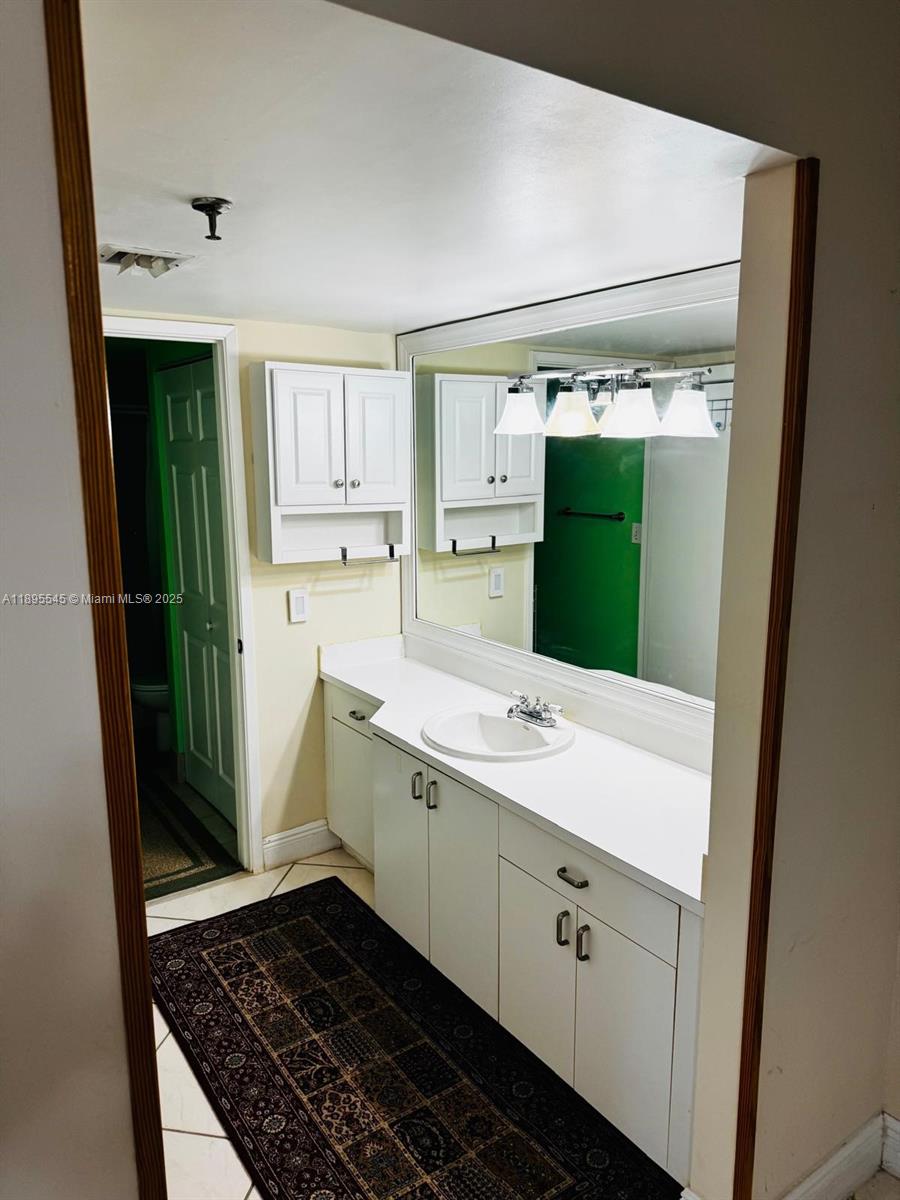 9156 Collins Avenue, Unit 310 Surfside, FL 33154 - Photo 14 of 22 a bathroom with a sink and a mirror