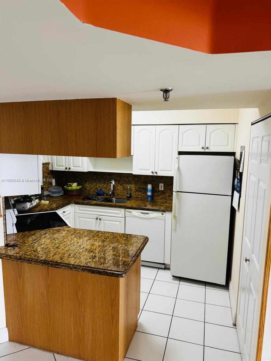 9156 Collins Avenue, Unit 310 Surfside, FL 33154 - Photo 10 of 22 a kitchen with a stove a refrigerator and a sink