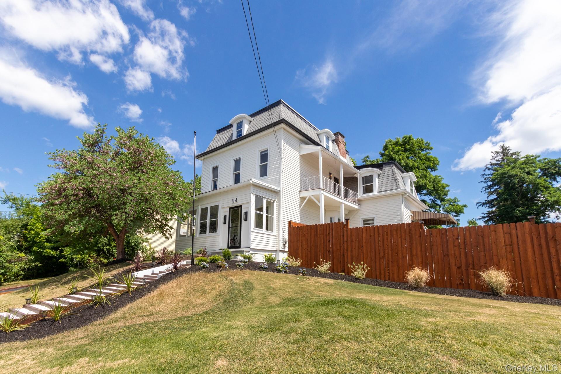 114 Rombout Avenue Beacon, NY 12508 - Photo 2 of 32 White multi-story residence featuring a mansard roof, dormer windows, and a front porch
