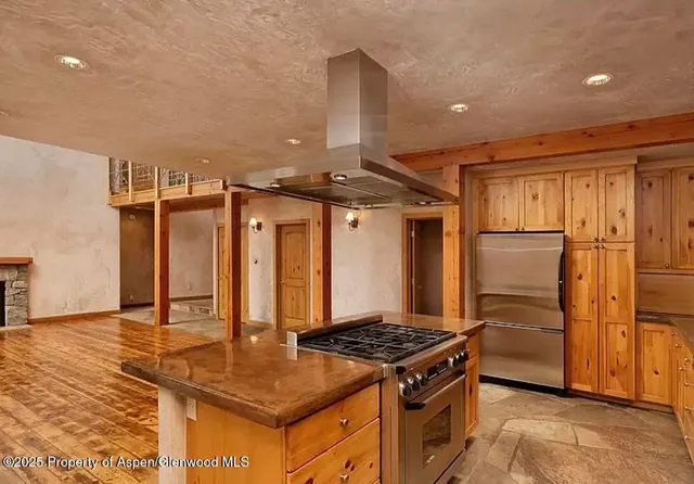 a kitchen with stainless steel appliances granite countertop a stove a refrigerator and a refrigerator