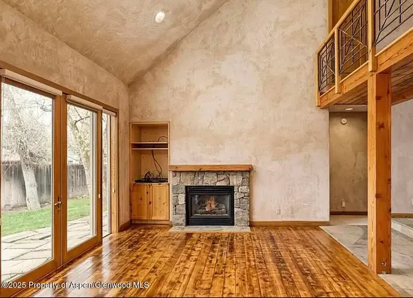 a view of an empty room with glass door and a fireplace