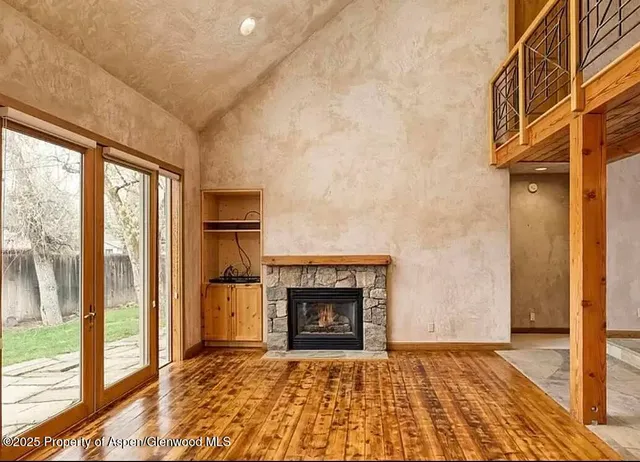 a view of an empty room with glass door and a fireplace