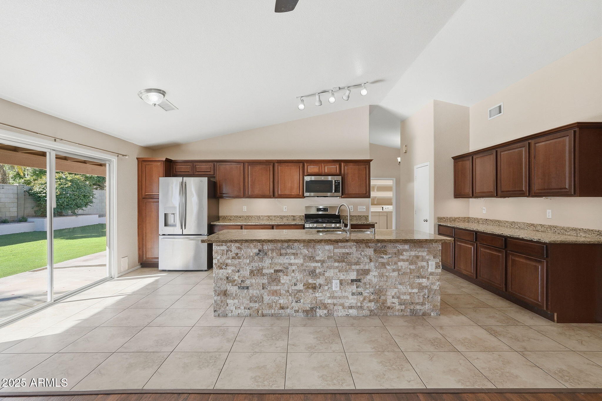 1619 East Carter Road Phoenix, AZ 85042 - Photo 22 of 56 a large kitchen with kitchen island granite countertop a large window and stainless steel appliances