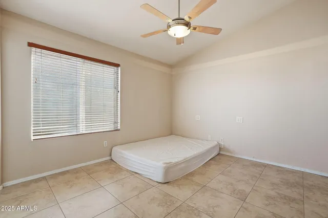 a view of an empty room and chandelier fan