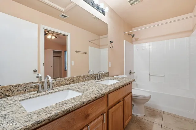 a bathroom with a granite countertop tub shower and mirror