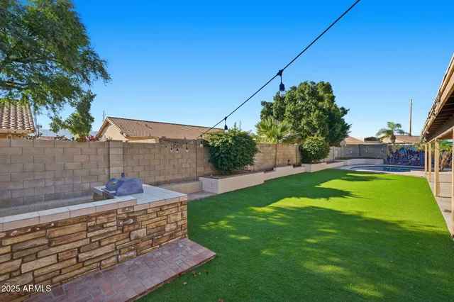 a view of a swimming pool with a yard and seating area