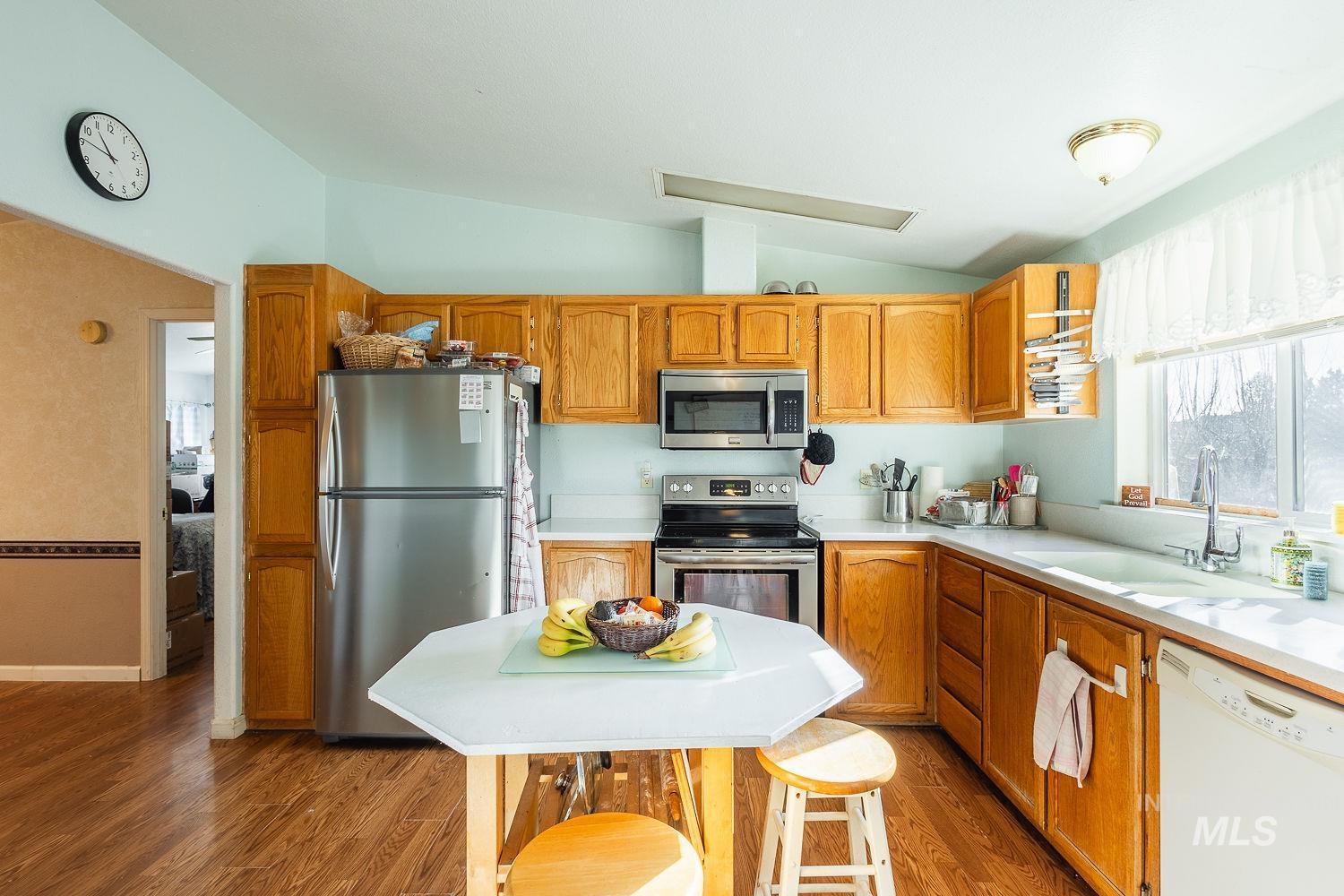 4119 Ashton Avenue Caldwell, ID 83607 - Photo 16 of 50 Kitchen with stainless steel appliances, vaulted ceiling, light wood-style flooring, and wood finish cabinets