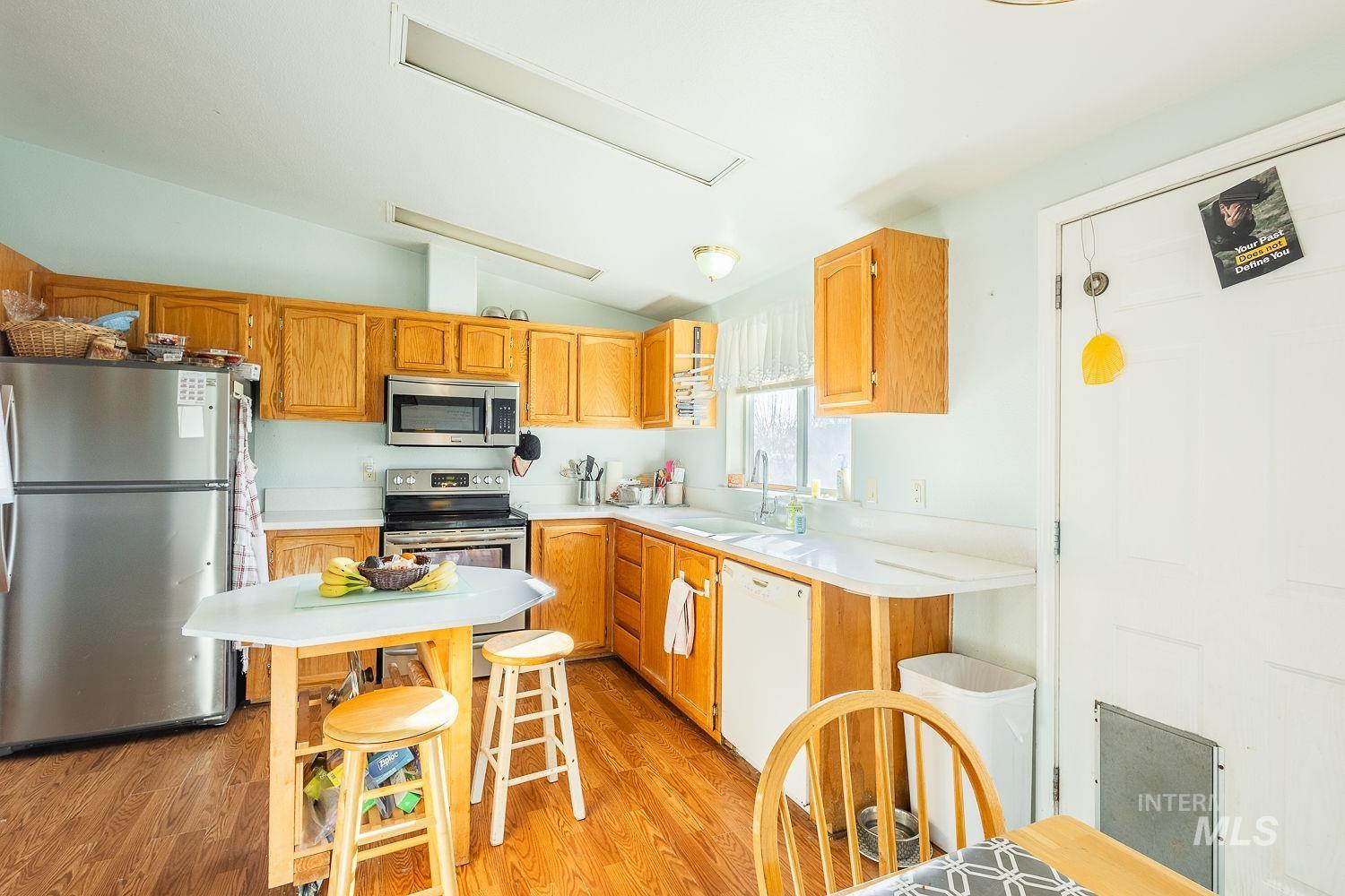 4119 Ashton Avenue Caldwell, ID 83607 - Photo 23 of 50 Kitchen with stainless steel appliances, light countertops, light wood finished floors, lofted ceiling, and wood finish cabinets