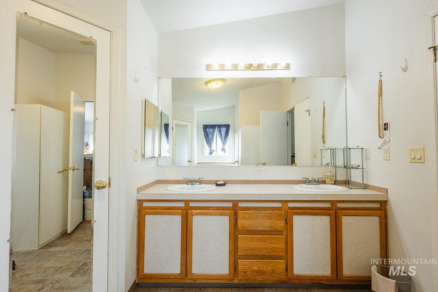 4119 Ashton Avenue Caldwell, ID 83607 - Photo 29 of 50 Full bath featuring double vanity, lofted ceiling, and stone finish floors
