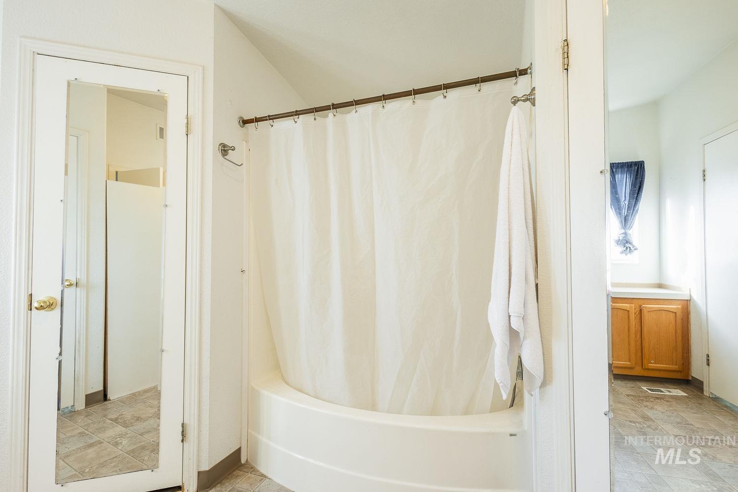 4119 Ashton Avenue Caldwell, ID 83607 - Photo 30 of 50 Full bathroom with shower / tub combo with curtain and stone finish flooring