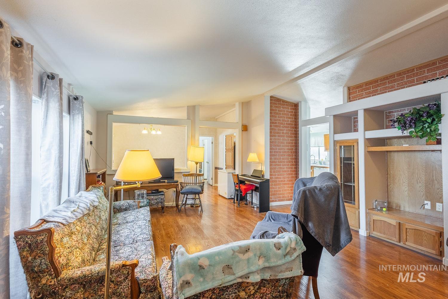 4119 Ashton Avenue Caldwell, ID 83607 - Photo 6 of 50 Living area featuring a chandelier, wood finished floors, and vaulted ceiling