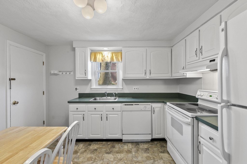 6 Dundee Road, Unit 6 Arlington, MA 02476 - Photo 12 of 29 a kitchen with granite countertop a sink and cabinets
