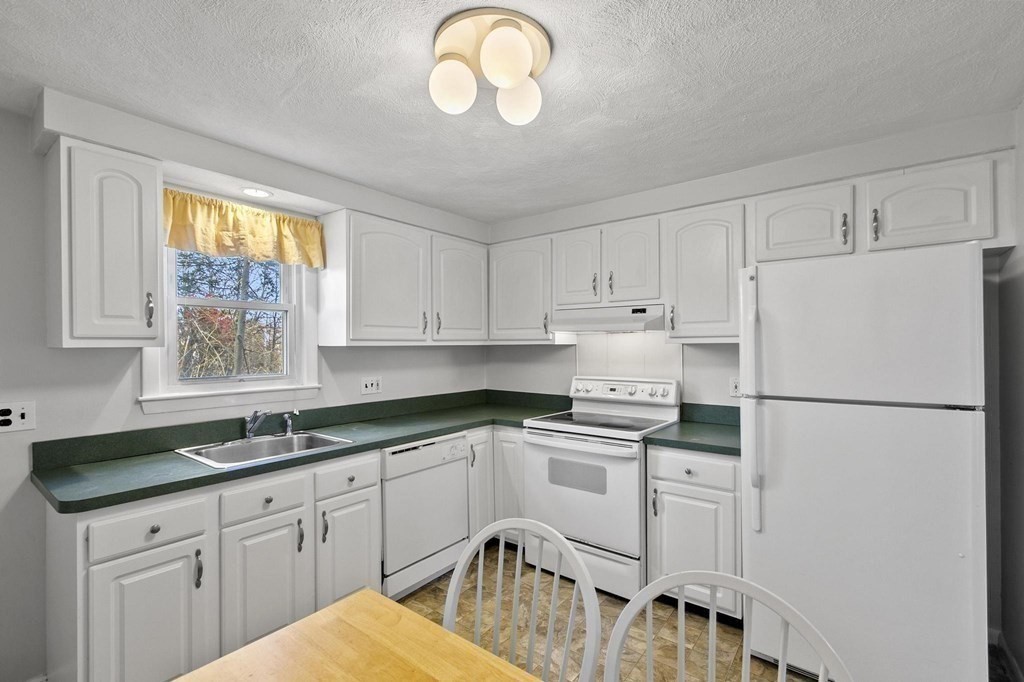 6 Dundee Road, Unit 6 Arlington, MA 02476 - Photo 14 of 29 a kitchen with white cabinets and white appliances