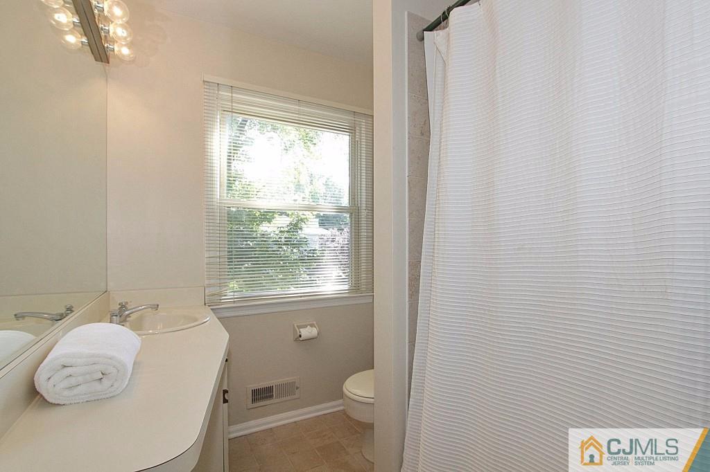 62 Harding Avenue Edison, NJ 08820 - Photo 16 of 24 a white toilet sitting next to a bathroom sink