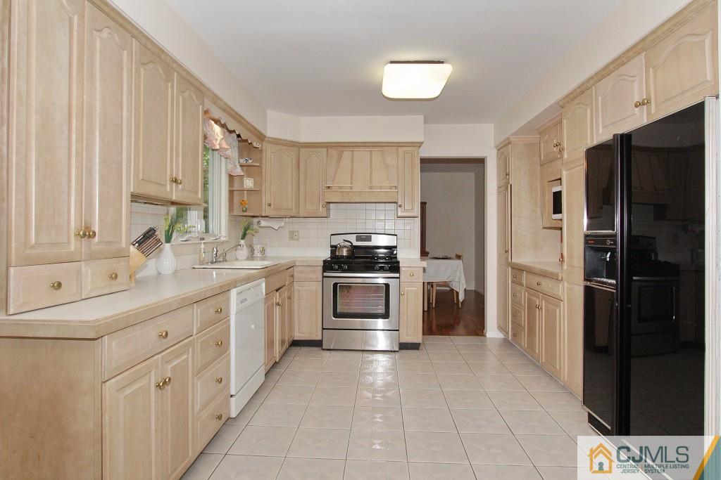 62 Harding Avenue Edison, NJ 08820 - Photo 9 of 24 a kitchen with white cabinets and stainless steel appliances