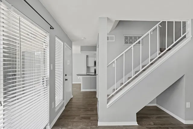 a view of entryway and hall with wooden floor