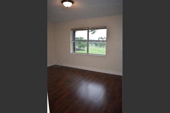 6101 North Falls Cir Drive, Unit 402 Lauderhill, FL 33319 - Photo 15 of 20 an empty room with wooden floor and windows