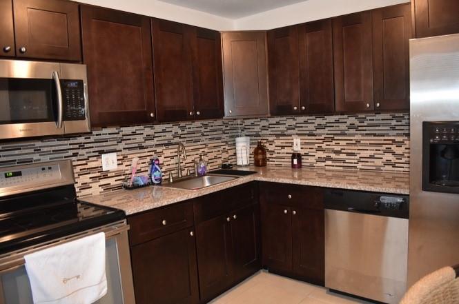 6101 North Falls Cir Drive, Unit 402 Lauderhill, FL 33319 - Photo 8 of 20 a kitchen with stainless steel appliances granite countertop a sink stove and microwave