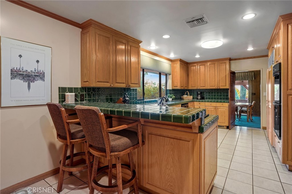 3620 Wrightwood Drive Studio City, CA 91604 - Photo 25 of 39 a dining hall with stainless steel appliances granite countertop a stove a sink a dining table and chairs with wooden floor