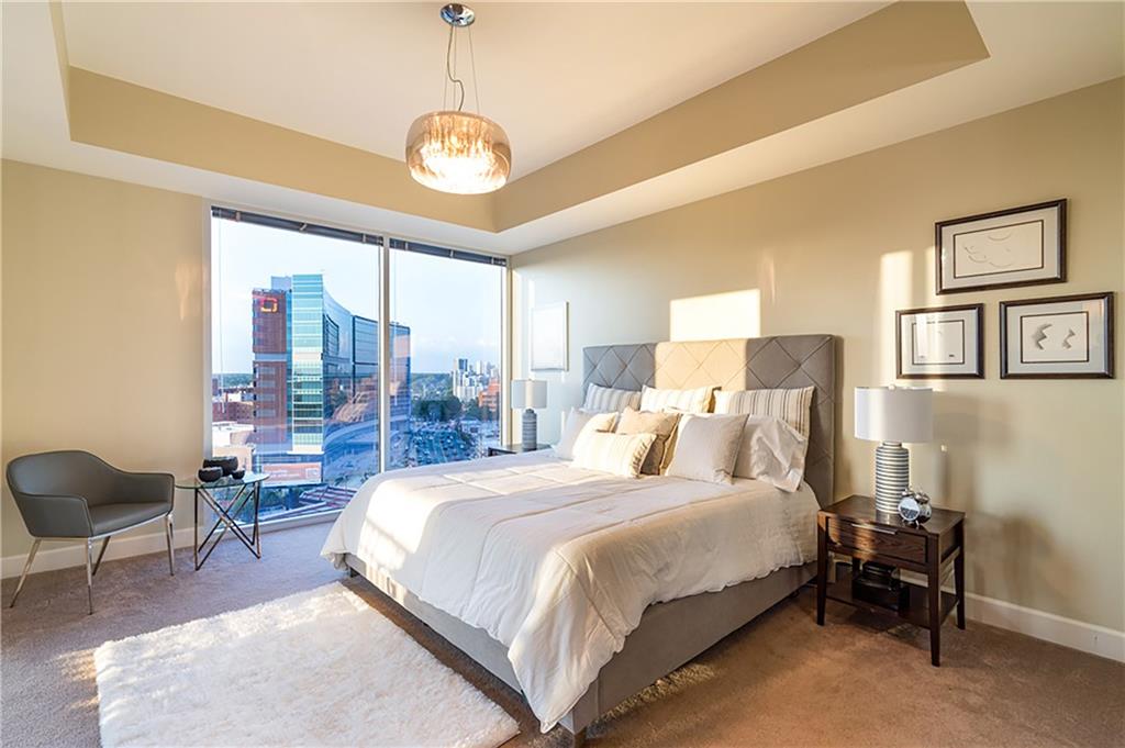 1820 Peachtree Road Northwest, Unit 1408 Atlanta, GA 30309 - Photo 11 of 37 a bedroom with a large bed and a chandelier
