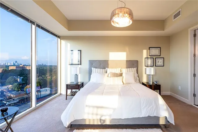 a spacious bedroom with a bed and a large window