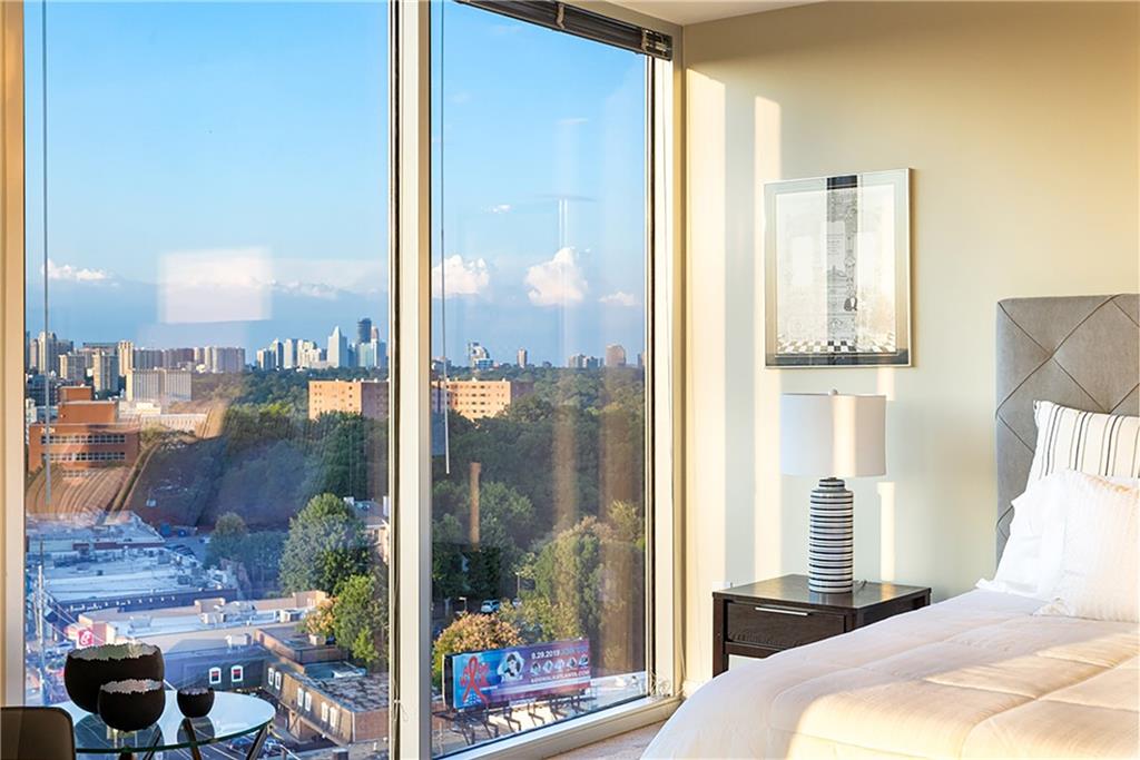 1820 Peachtree Road Northwest, Unit 1408 Atlanta, GA 30309 - Photo 13 of 37 a bedroom with a bed and glass window