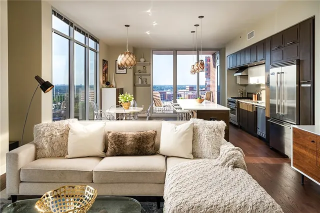 a living room with furniture kitchen and a large window