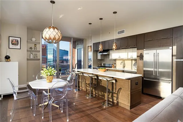 a kitchen with stainless steel appliances a table chairs and a chandelier