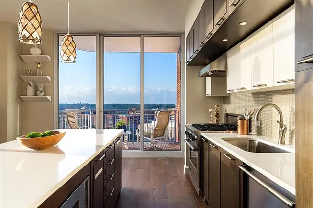 a kitchen with stainless steel appliances a sink a stove top oven a chimney and a center island