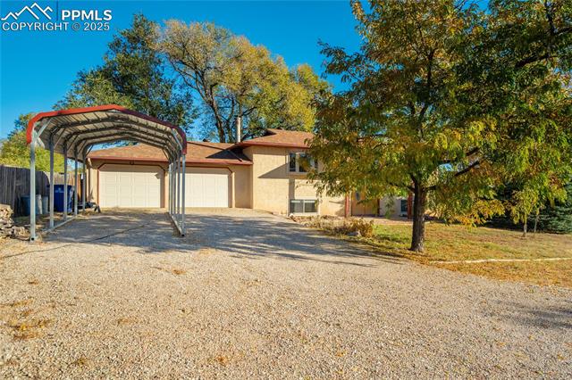 8340 Piute Road Colorado Springs, CO 80926 - Photo 40 of 48 View of front of property with driveway, stucco siding, and a carport