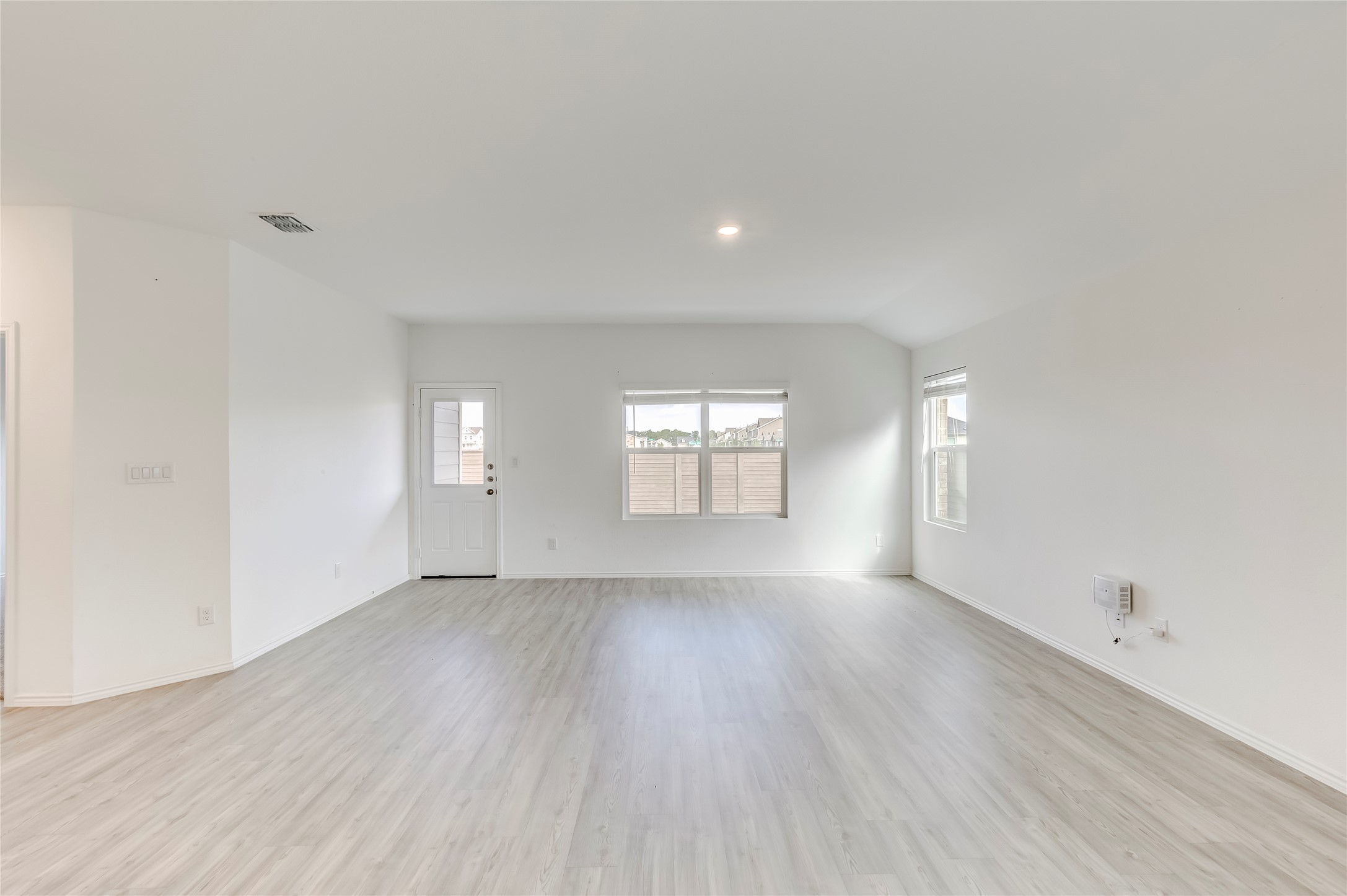 591 Avre Loop Kyle, TX 78640 - Photo 7 of 34 an empty room with wooden floor and windows
