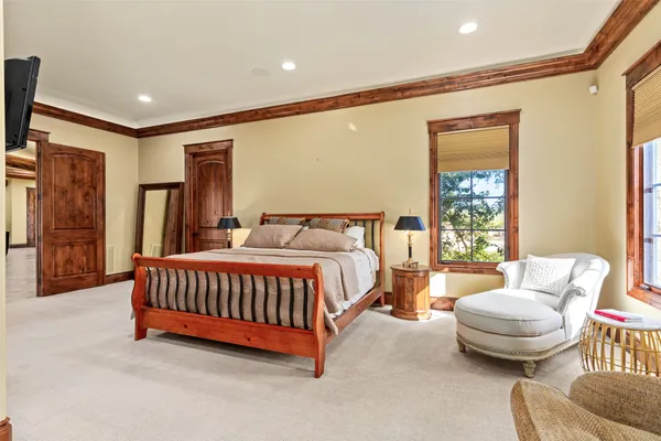 a spacious bedroom with a bed and glass window