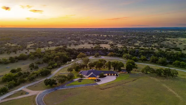 an aerial view of a house with a swimming pool yard and mountain view in back