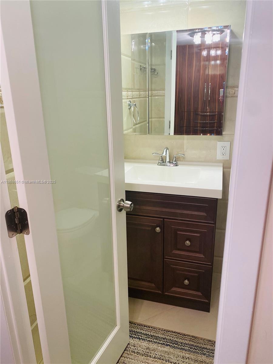 230 174th Street, Unit 507 Sunny Isles Beach, FL 33160 - Photo 13 of 28 a bathroom with a sink and a mirror