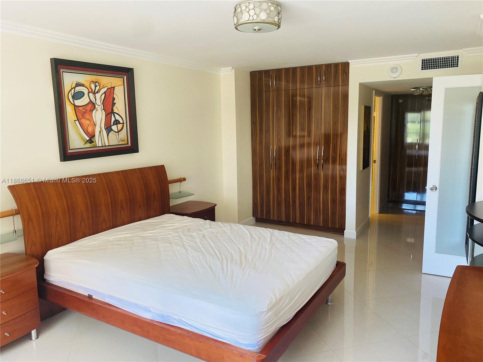 230 174th Street, Unit 507 Sunny Isles Beach, FL 33160 - Photo 18 of 28 a bedroom with a bed and a painting on the wall