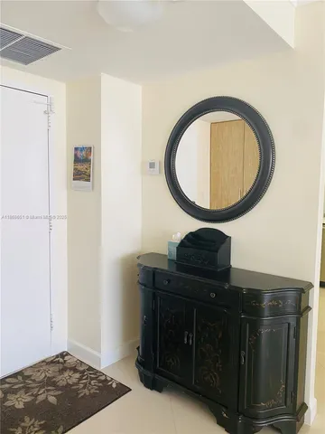 a living room with a dresser and a mirror