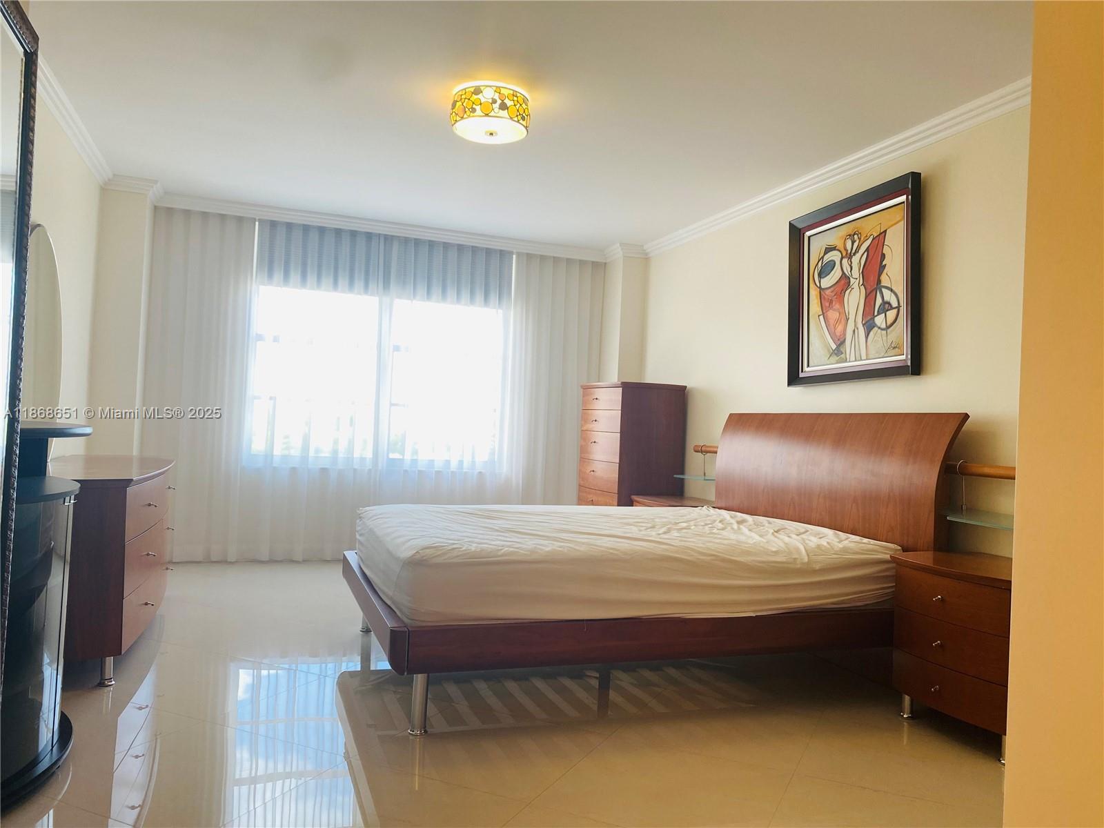 230 174th Street, Unit 507 Sunny Isles Beach, FL 33160 - Photo 21 of 28 a bedroom with a bed and a painting on the wall