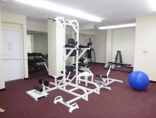 a room with gym equipment and wooden floor