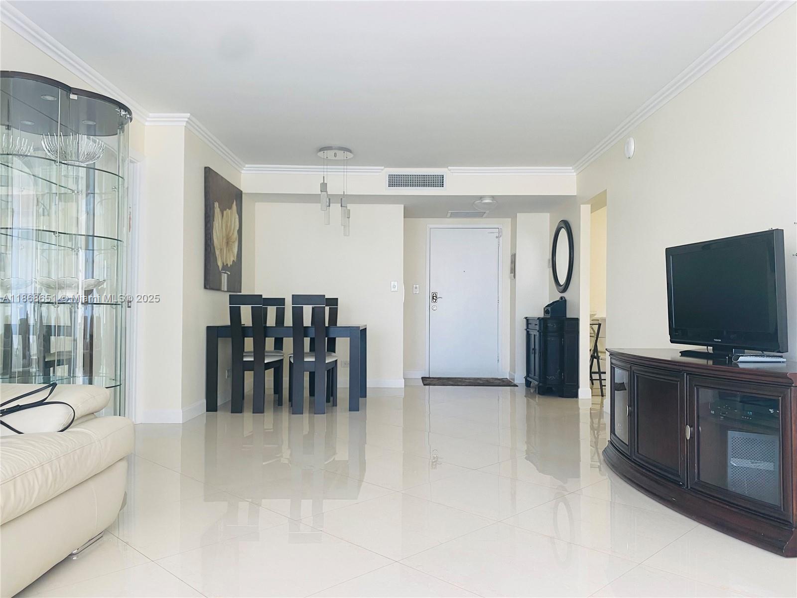 230 174th Street, Unit 507 Sunny Isles Beach, FL 33160 - Photo 4 of 28 a view of a livingroom with furniture and a flat screen tv