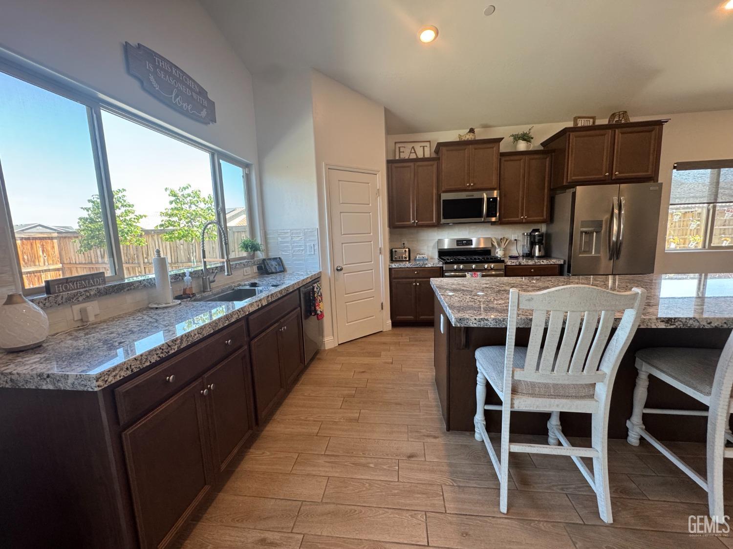 Undisclosed Address Shafter, CA 93263 - Photo 16 of 46 a kitchen with stainless steel appliances granite countertop a stove a sink a microwave a counter space and cabinets