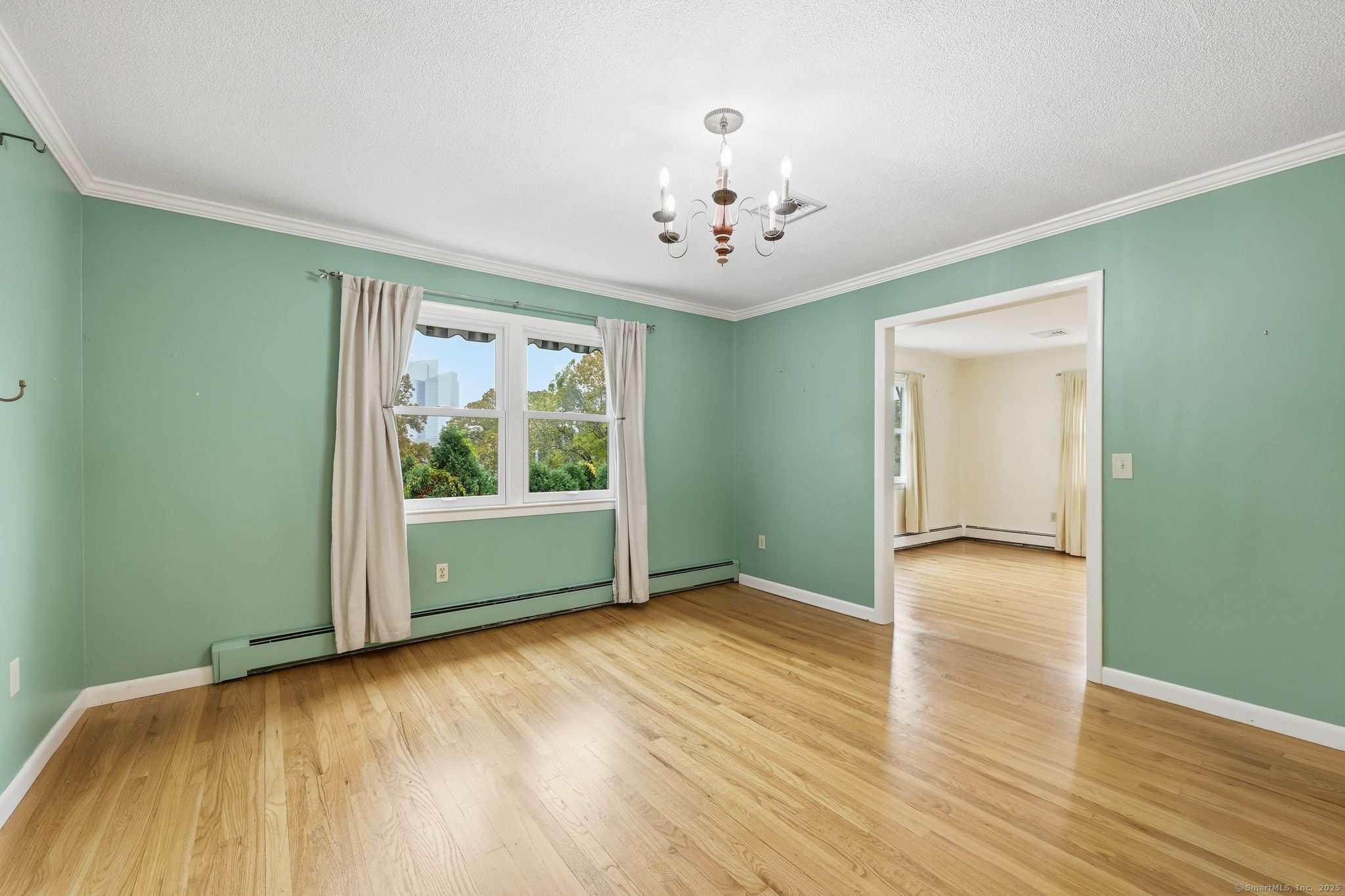 102 Lucas Park Road Norwich, CT 06360 - Photo 3 of 37 a view of an empty room with wooden floor and a window