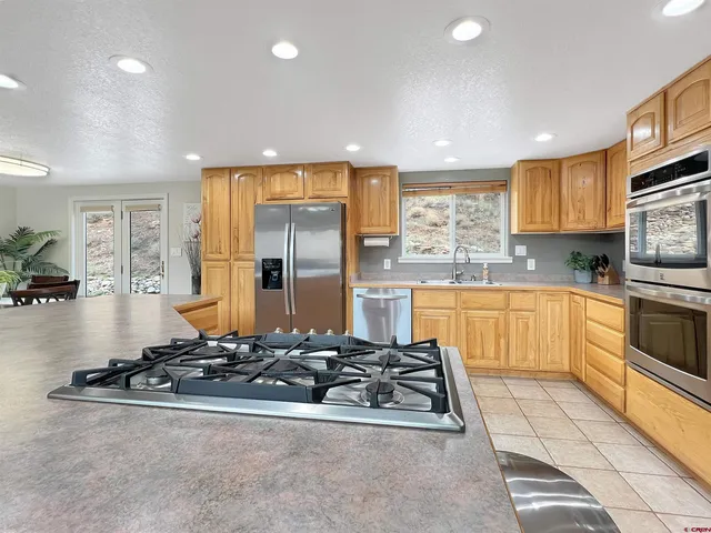 a kitchen with stainless steel appliances a sink stove and refrigerator