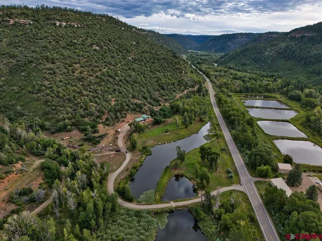 an aerial view of residential houses with outdoor space and trees
