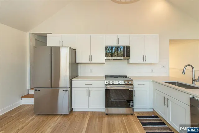 a view of empty room with wooden floor and fireplace