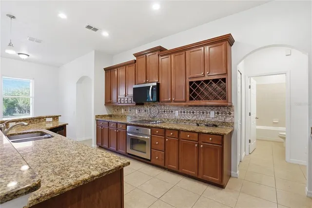 a kitchen with stainless steel appliances granite countertop a sink and a stove