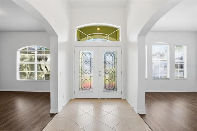 an entryway with wooden floor windows and brick walls