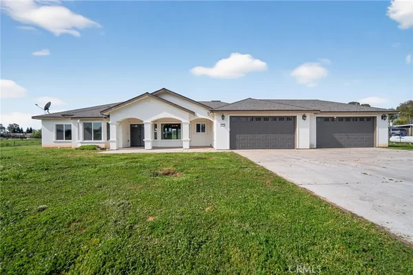 a front view of a house with a garden and yard